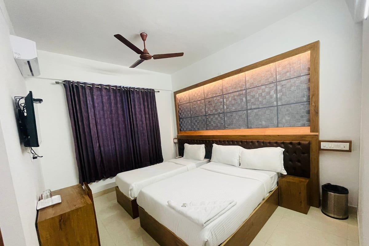 A double bed with a wooden headboard, a ceiling fan, and a brick-patterned wall above it.