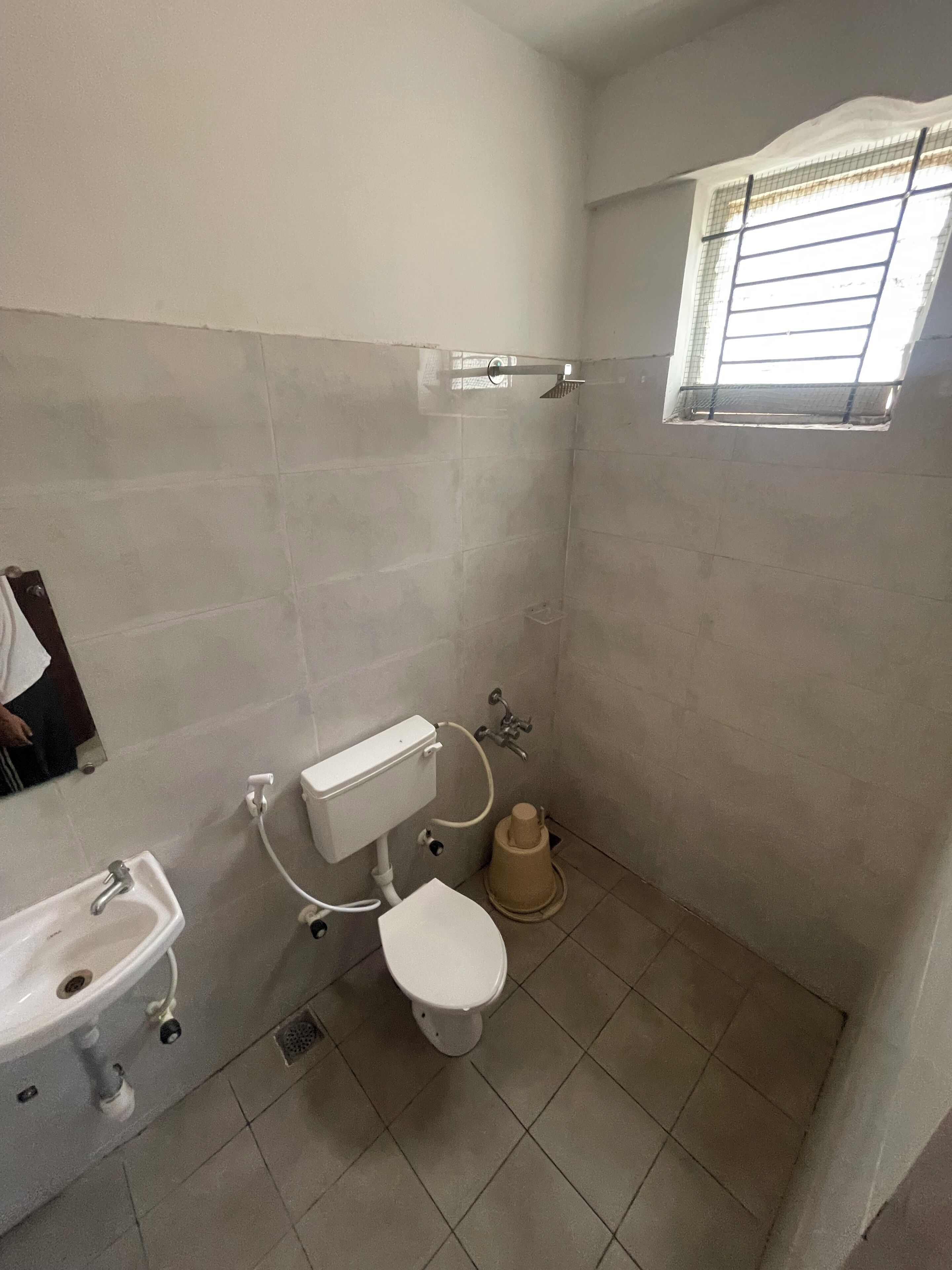 A small bathroom with a toilet, sink, and shower.