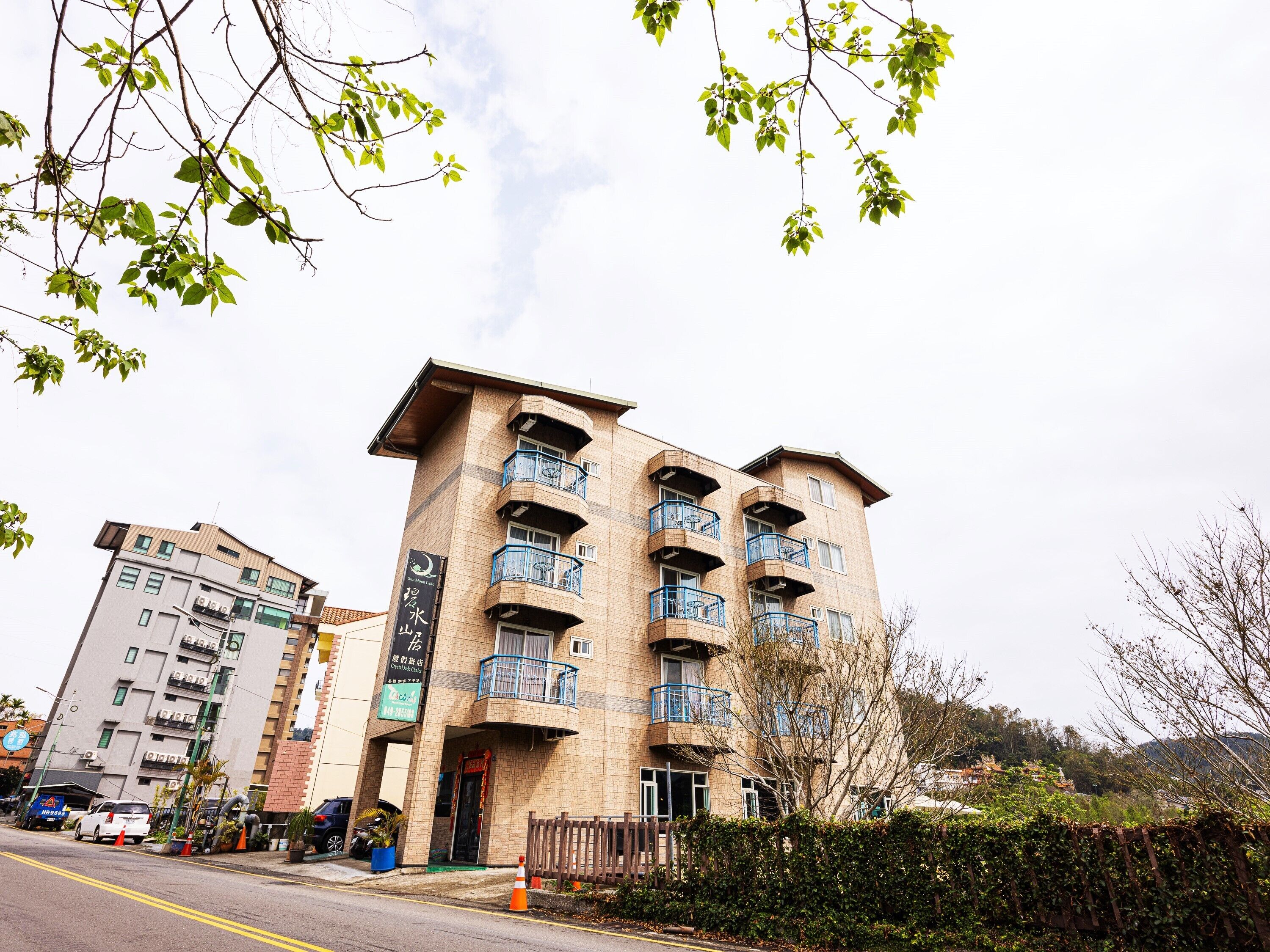 A multi-story building with balconies, a sign indicating a restaurant, and a clear sky.