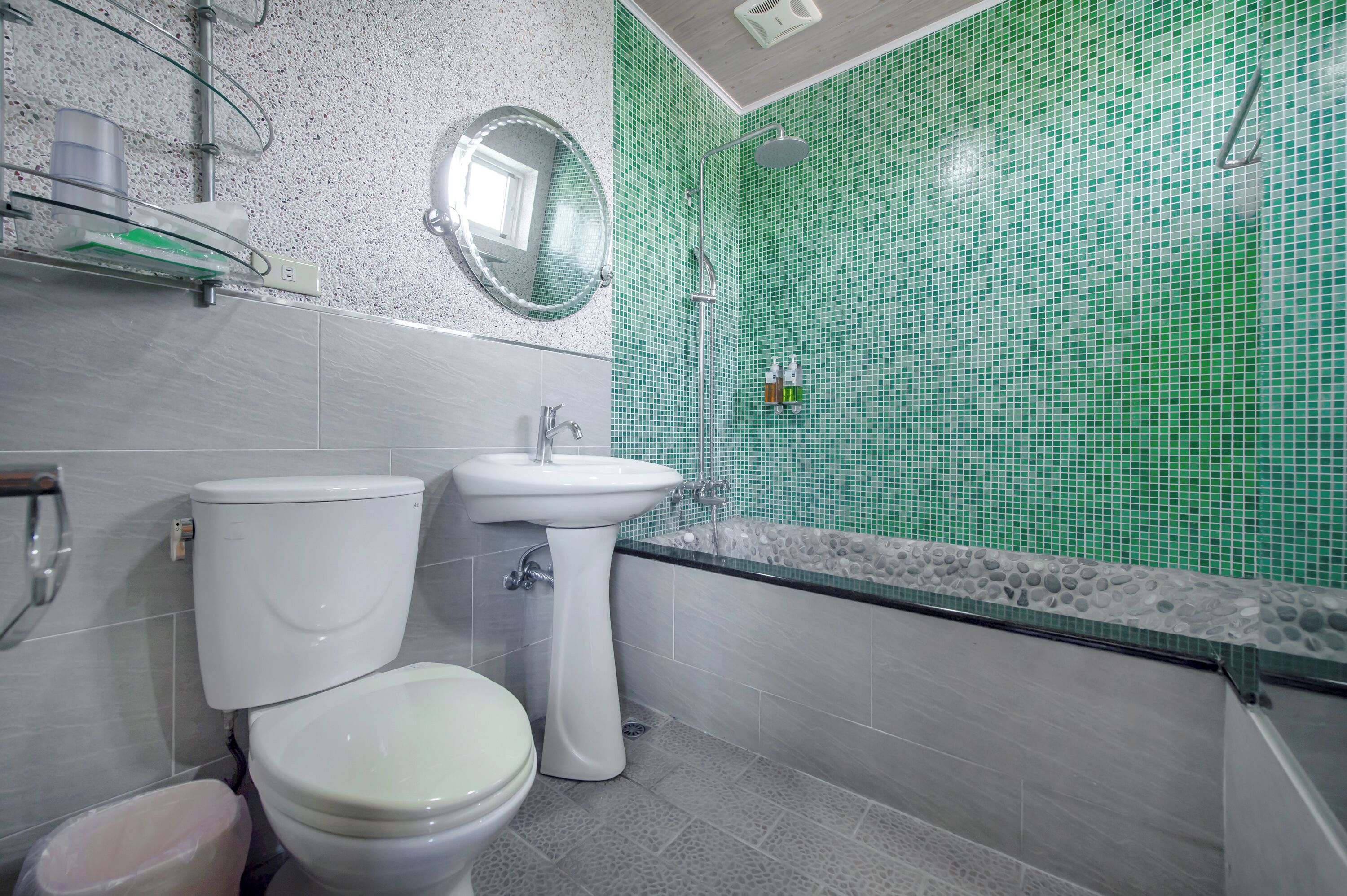 Un baño con inodoro, lavamanos y ducha.
