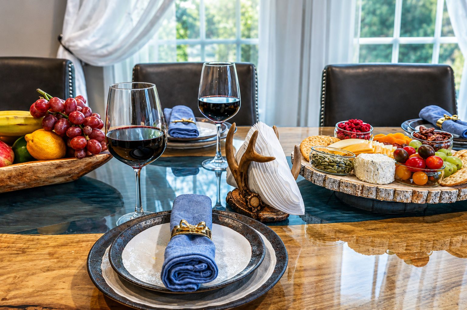 A dining table with a variety of food items, wine glasses, and a decorative centerpiece.
