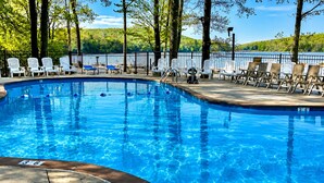 Piscina con sillas y vista a un lago.