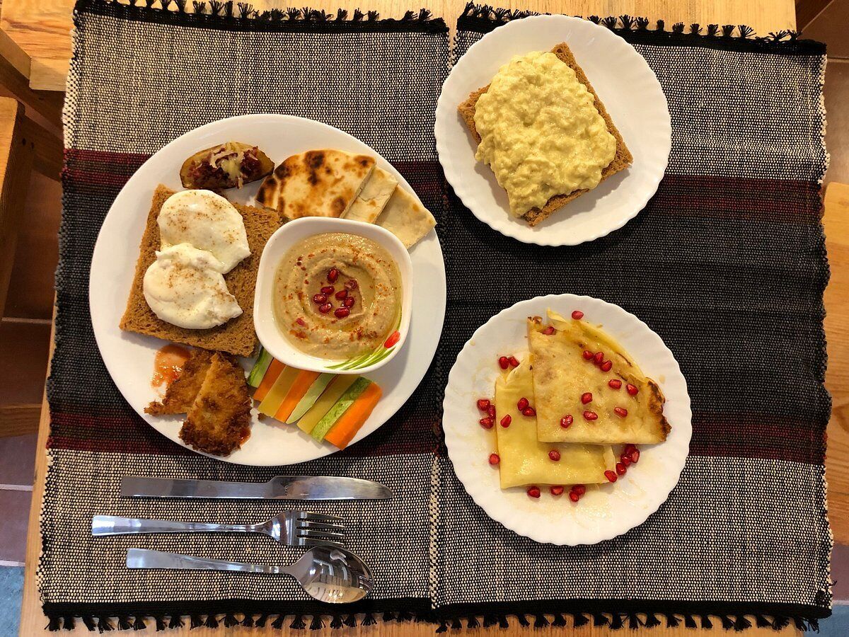 A meal with bread, hummus, and a side of vegetables.