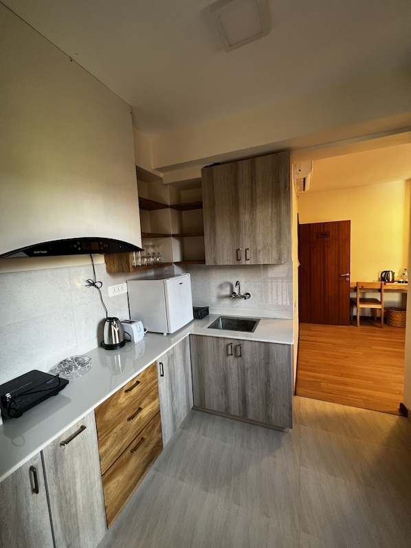 Una cocina compacta con horno integrado, pileta y armarios de madera.