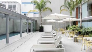 A rooftop pool area with sun loungers, outdoor tables, and umbrellas. - Mexican apartment in Polanco. Pool - gym - parking (Ciudad de México)
