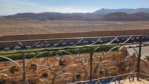 A balcony with a view of a desert landscape and mountains. - Royal Mountain Hotel (Luxor)