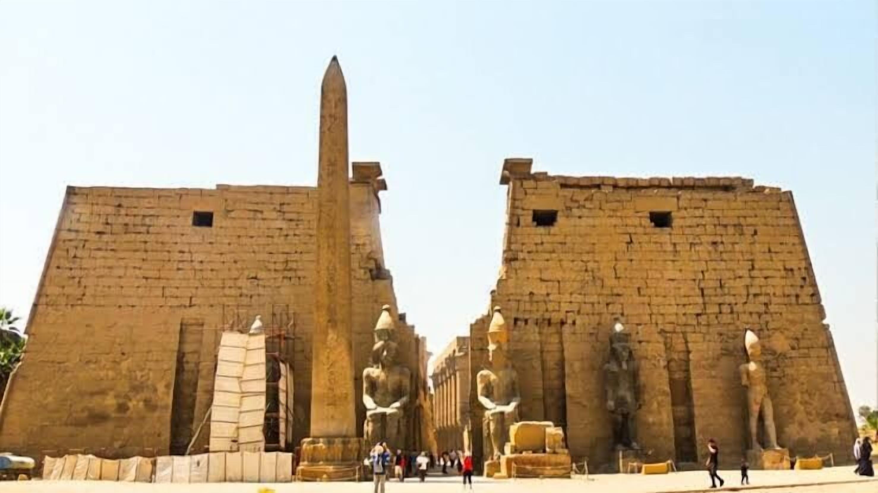 Una gran estructura de piedra con dos obeliscos y estatuas destacadas.