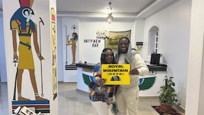 A hotel lobby with a reception desk, a 'Happy New Year' banner, and a 'Royal Mountain Hotel' sign. - Royal Mountain Hotel (Luxor)