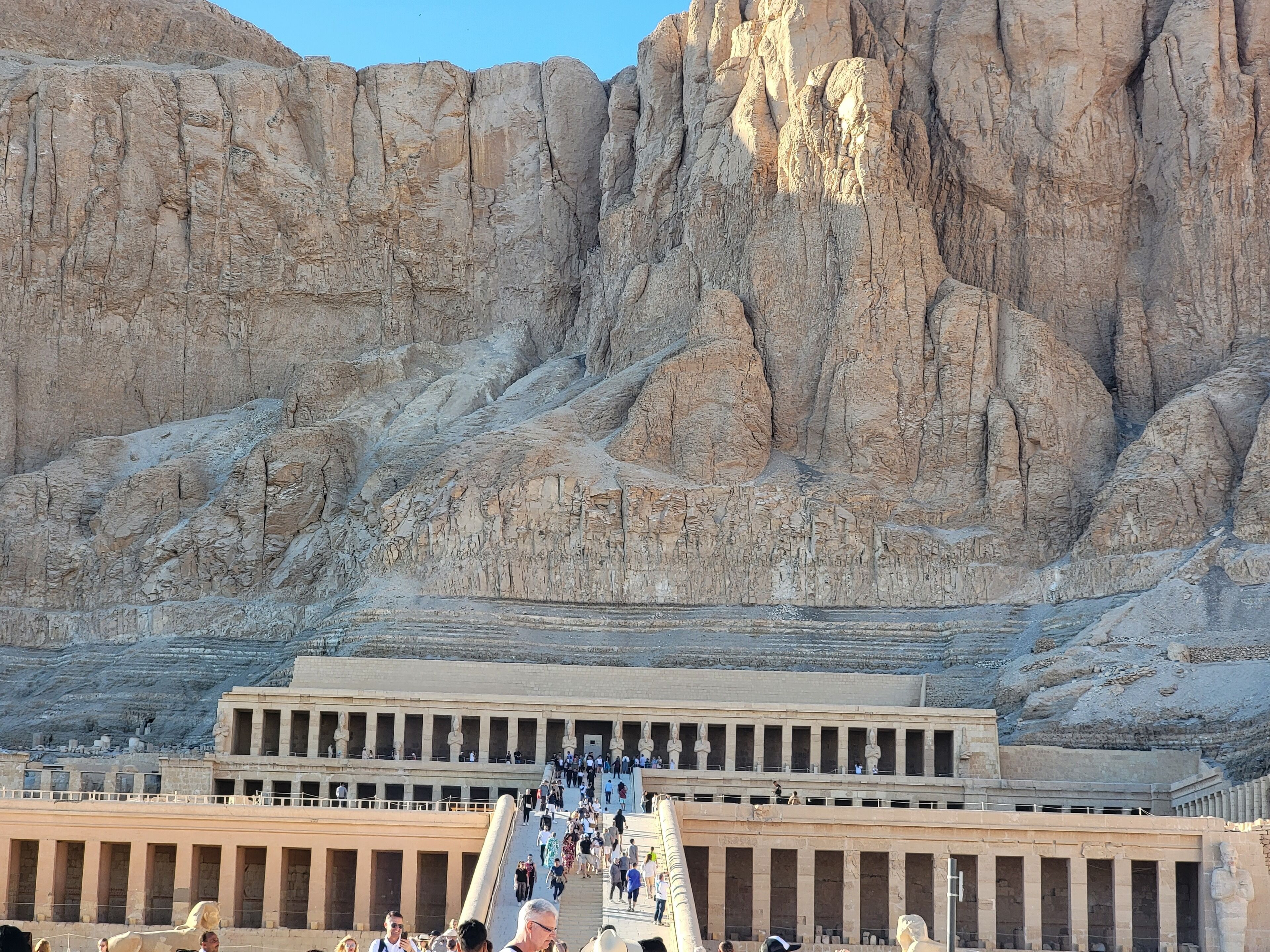 Une vaste structure de pierre, datant de l’Antiquité, avec un grand escalier menant à un édifice qui ressemble à un temple.