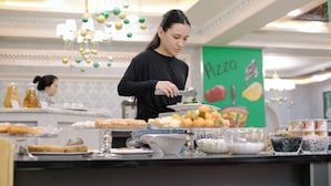 Een buffet met diverse gerechten en een persoon die serveert.