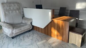 Un salon moderne avec un fauteuil moelleux, une table basse en bois et un tapis à motifs de marbre.