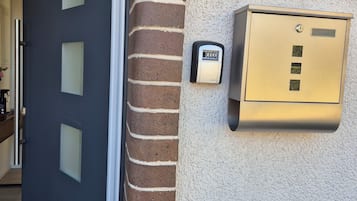 Una entrada de edificio moderno con una puerta, un buzón y el número 30 en la pared.