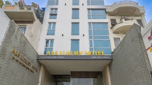 The A25 Luxury Hotel entrance with a modern design, featuring a prominent entrance, a staircase leading up, and potted plants around the area. - A25 Premium Hotel - 55 Cach Mang Thang 8 (Ho Chi Minh City)