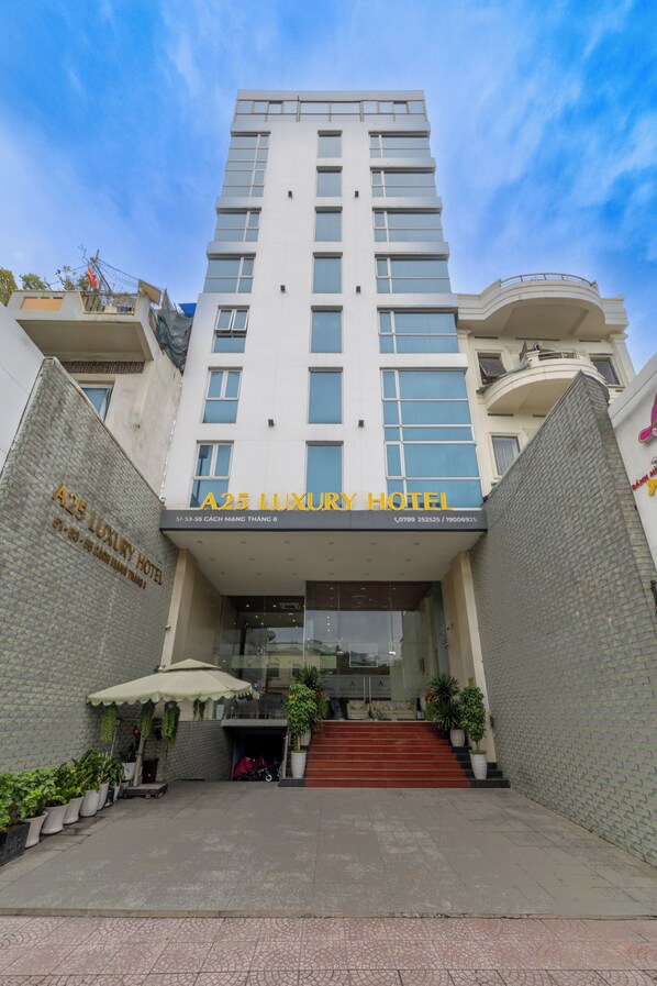 The A25 Luxury Hotel entrance with a modern design, featuring a prominent entrance, a staircase leading up, and potted plants around the area. - A25 Premium Hotel - 55 Cach Mang Thang 8 (Ho Chi Minh City)