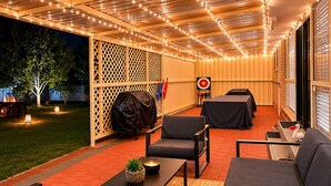 An outdoor patio area with seating, string lights, and a target on the wall. - Pelicans Rest Albany, 5 min to the beach, 6 min to city. Great all year round! (Collingwood Park)
