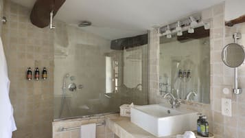 Une salle de bain avec une grande baignoire, un double vasque et un espace douche.