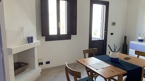 Ein Essbereich mit Holztisch, Stühlen und einem Fenster mit Aussicht.