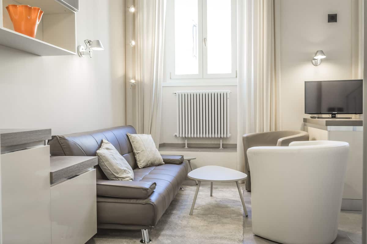 A modern living room with a sofa, a round table, and a television.