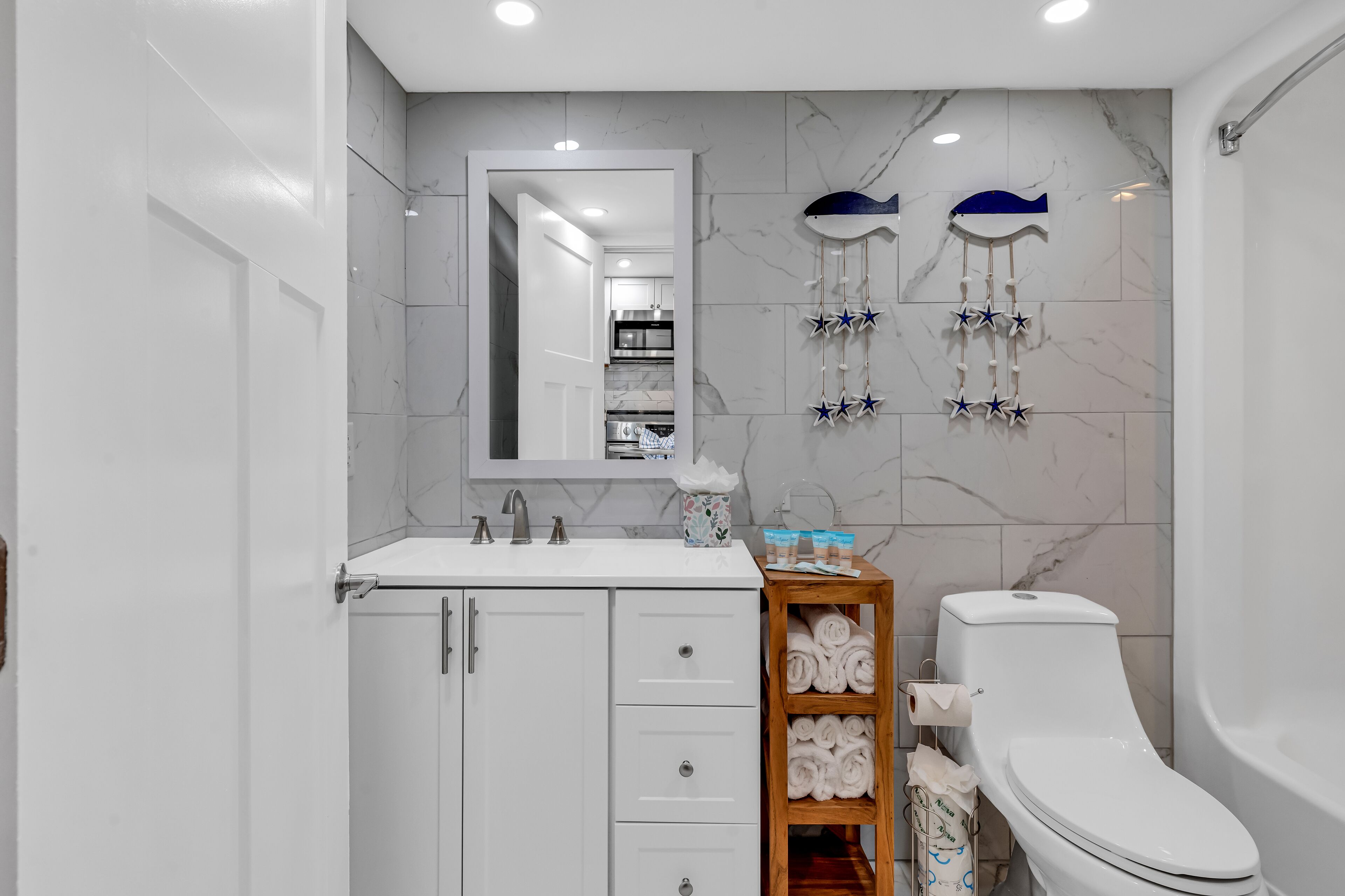 Une salle de bain moderne avec un meuble-lavabo blanc, des toilettes et un espace douche.
