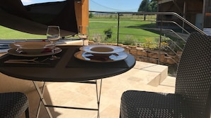 A table set outdoors with a view of a golf course. - Les Chambres du golf - Golf de La Chassagne (Malain)