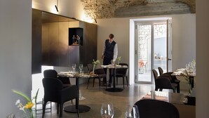 Un comedor moderno con techo de piedra, mobiliario contemporáneo y vistas al exterior.