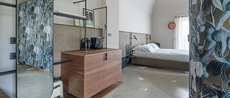 Una habitación de hotel moderna con un aparador de madera, un espejo, una cama y una pared con estampado floral.