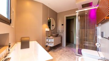A modern bathroom with a large bathtub, a separate shower area, and a vanity with a sink and mirror.