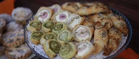 A plate of assorted pastries, including some with visible fillings and others topped with seeds.