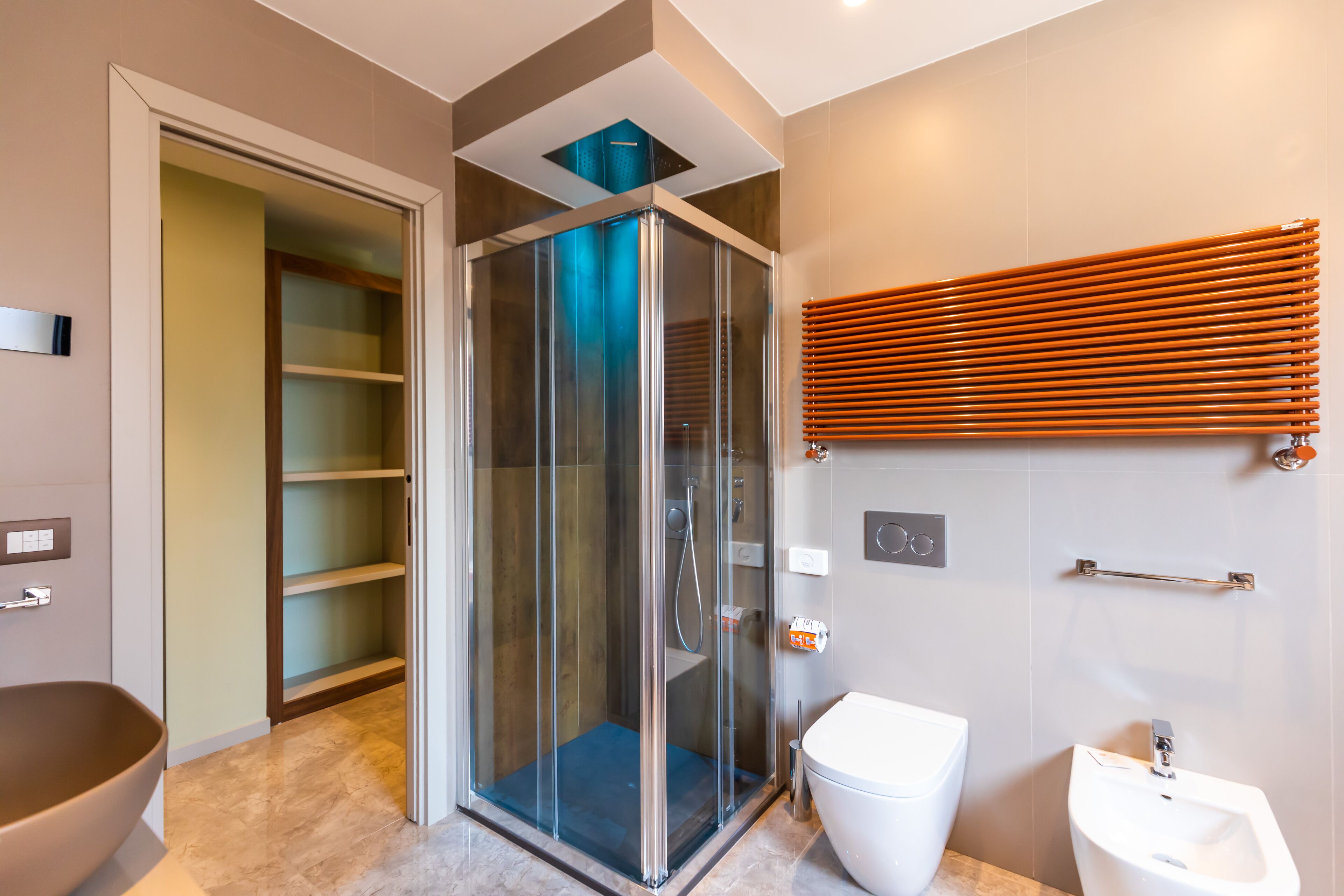 Une salle de bain moderne avec une douche à parois de verre, un lavabo blanc et un bidet.