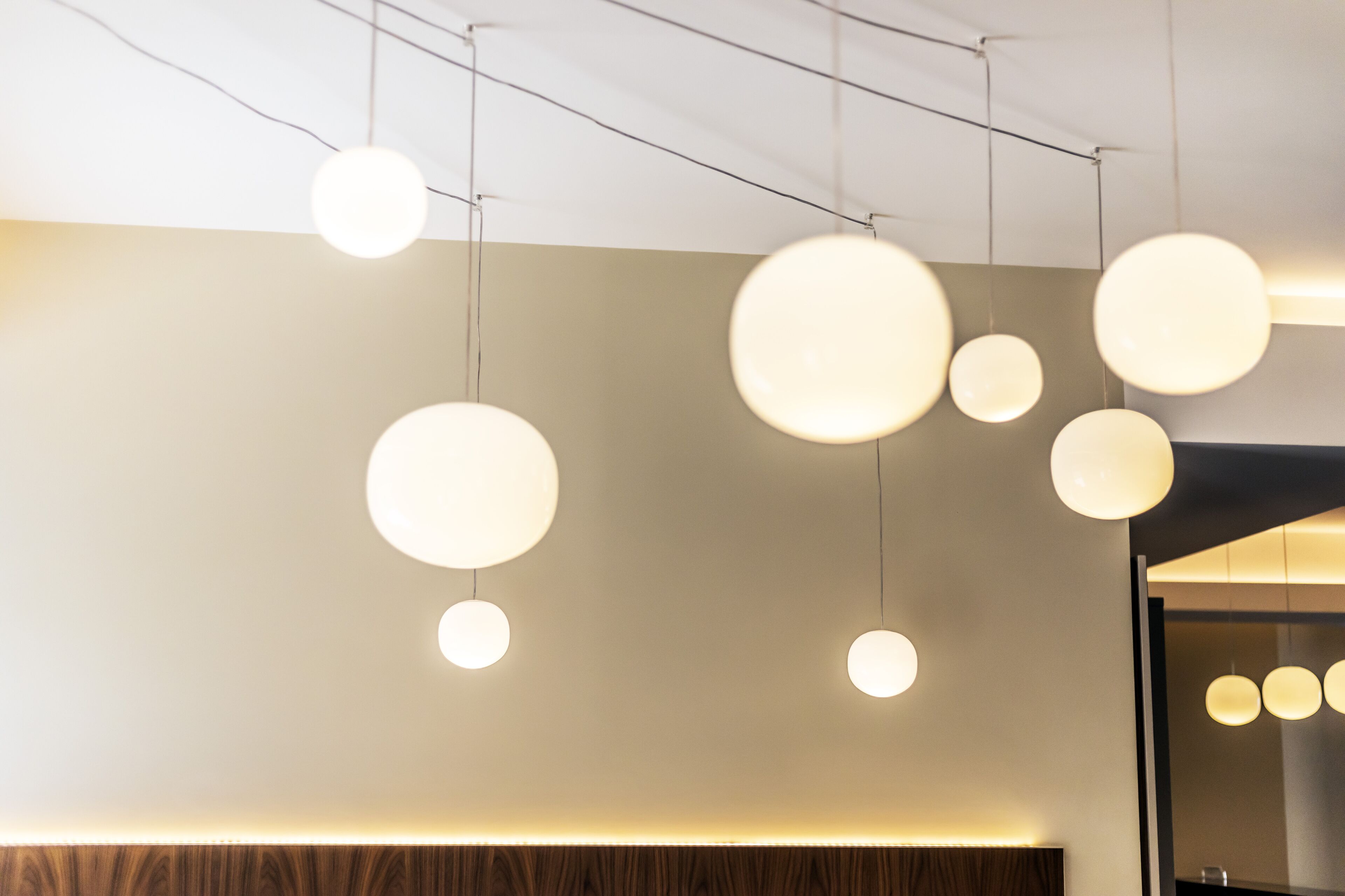 A modern interior with pendant lighting and a wooden panel wall.