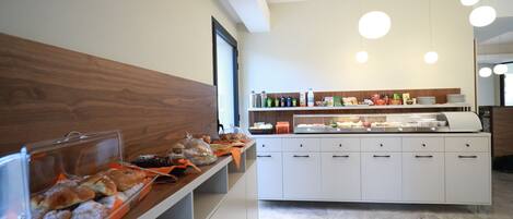 Een moderne ontbijtbalk met diverse gebakjes en een bedieningsstation.