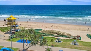 A beach with a lifeguard tower, picnic tables, and a clear view of the ocean.