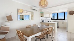 A modern kitchen with white cabinets, a large island, and a view of the outdoors.