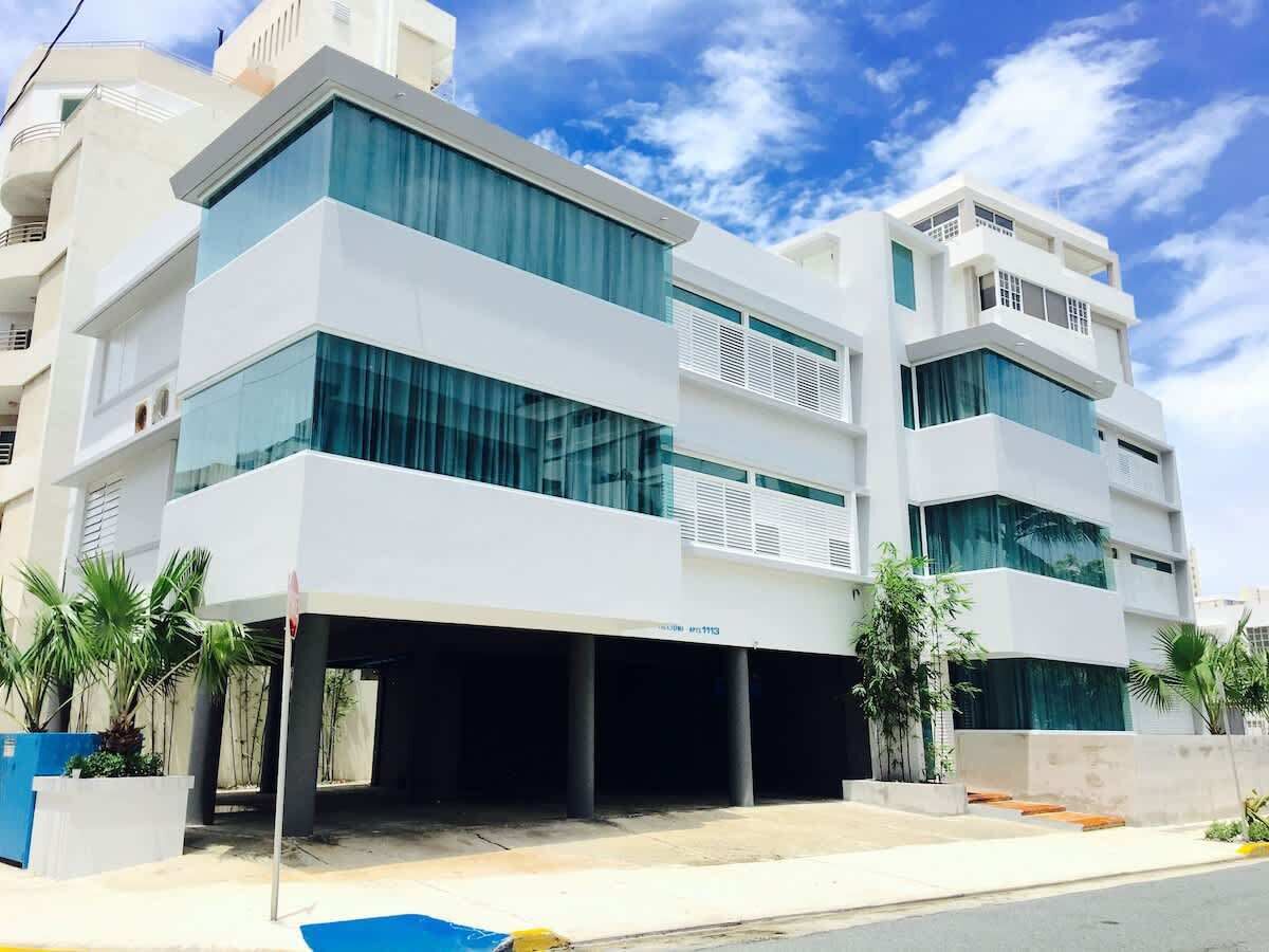 A modern multi-story building with large windows and a covered entrance.