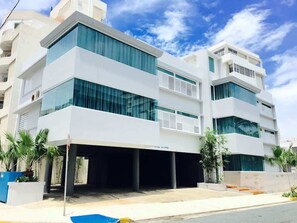Un edificio moderno de varios pisos con grandes ventanales y un vestíbulo cubierto.