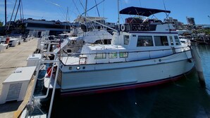 A marina with boats docked, a clear sky, and a bright sun.