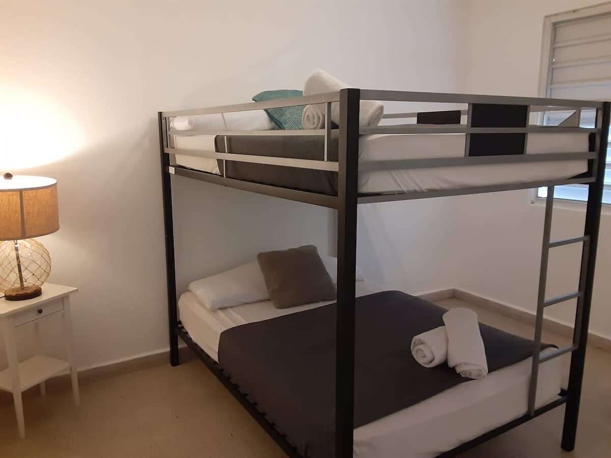 Una cama litera con una mesita de noche y una lámpara.