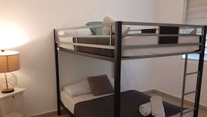 A bunk bed with a nightstand and a lamp.