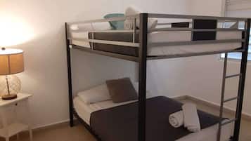 Una cama litera con una mesita de noche y una lámpara.