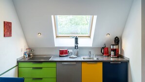 Eine kompakte Küche mit Oberlicht, Spüle und modernen Geräten.
