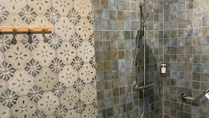 Een douchegedeelte met een regendouche, een handdouche en een handdouche.