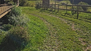 Een houten gebouw in rustieke stijl met een balkon dat uitkijkt over een weelderig groen landschap.