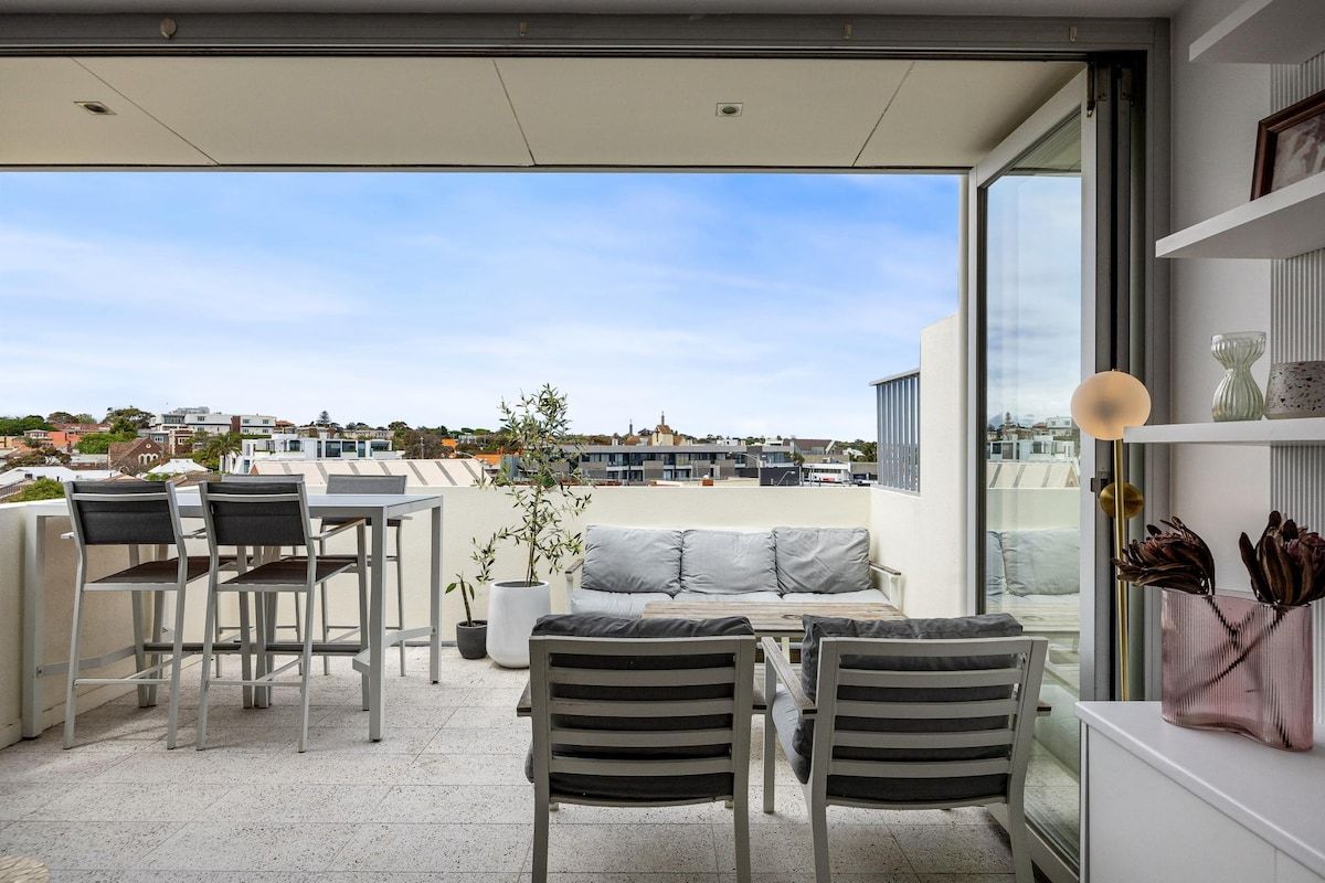 A modern outdoor seating area with a view of the cityscape.