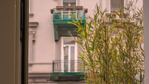 A view from a balcony with a metal railing, overlooking a building with multiple floors and balconies. - Hart Boutique Rooms (Naples)