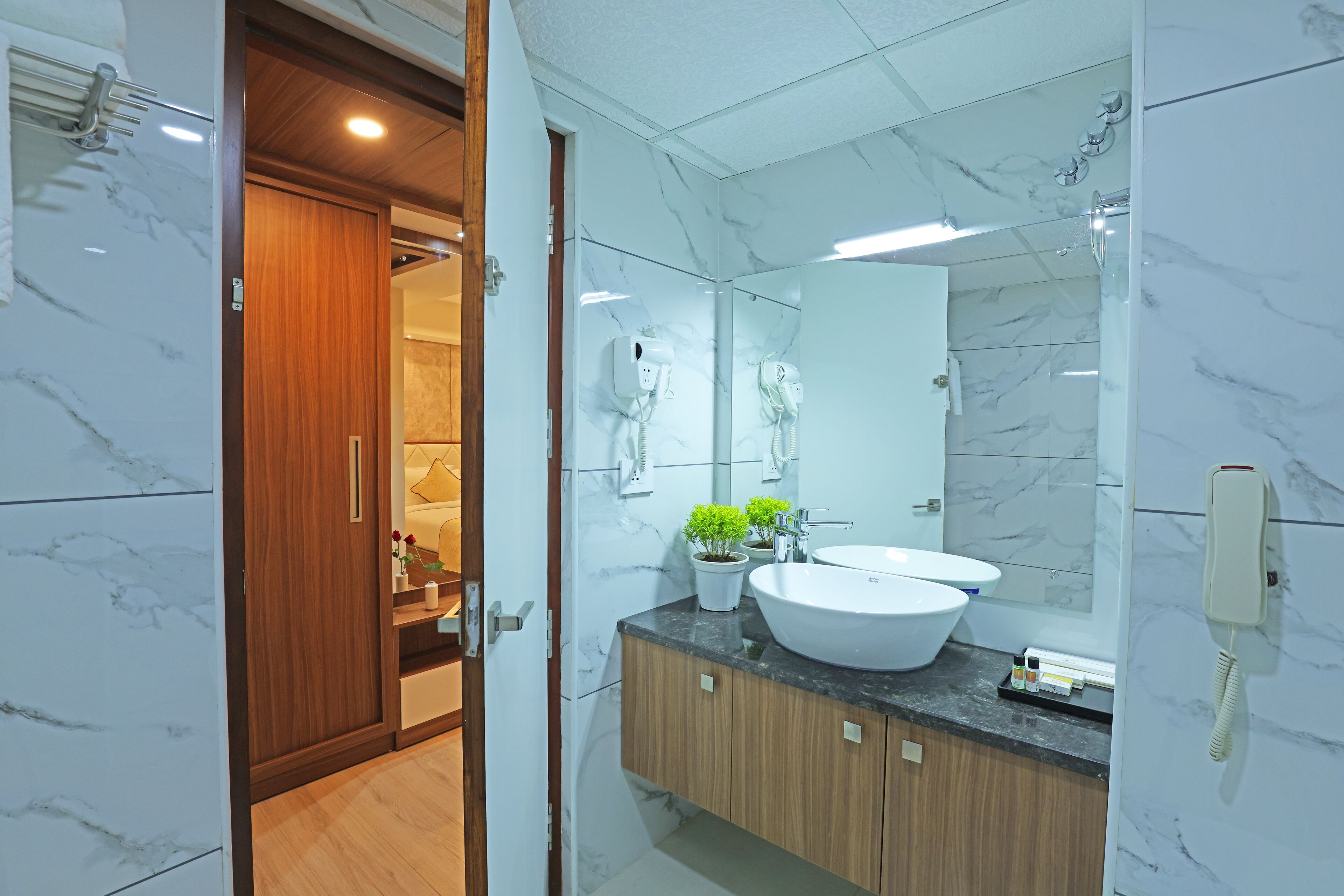 A modern bathroom with a large mirror, two sinks, and a wooden cabinet.