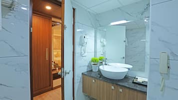 A modern bathroom with a large mirror, two sinks, and a wooden cabinet.