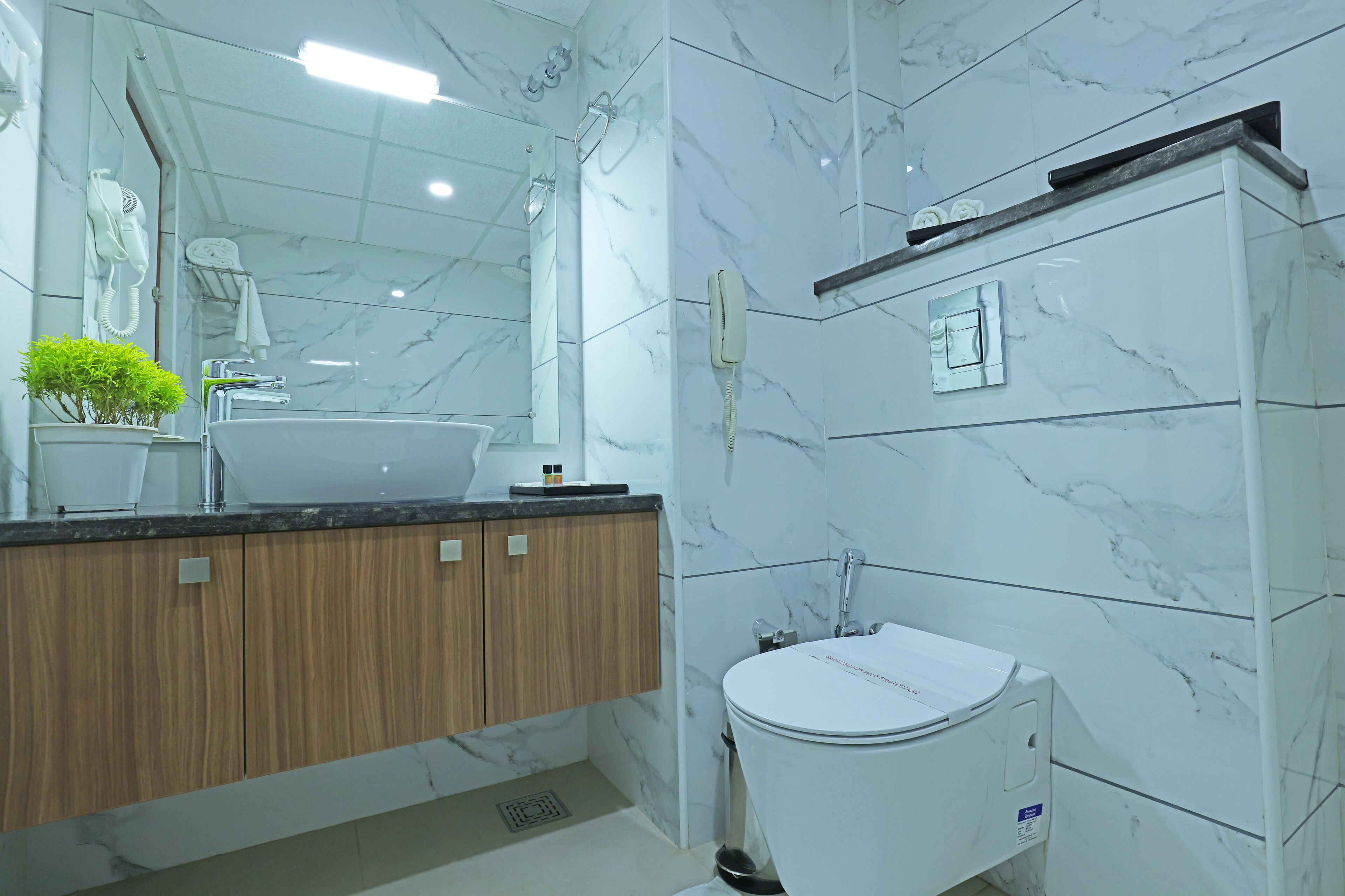 Une salle de bain moderne avec un meuble-lavabo en marbre, un lavabo, des toilettes et une douche.