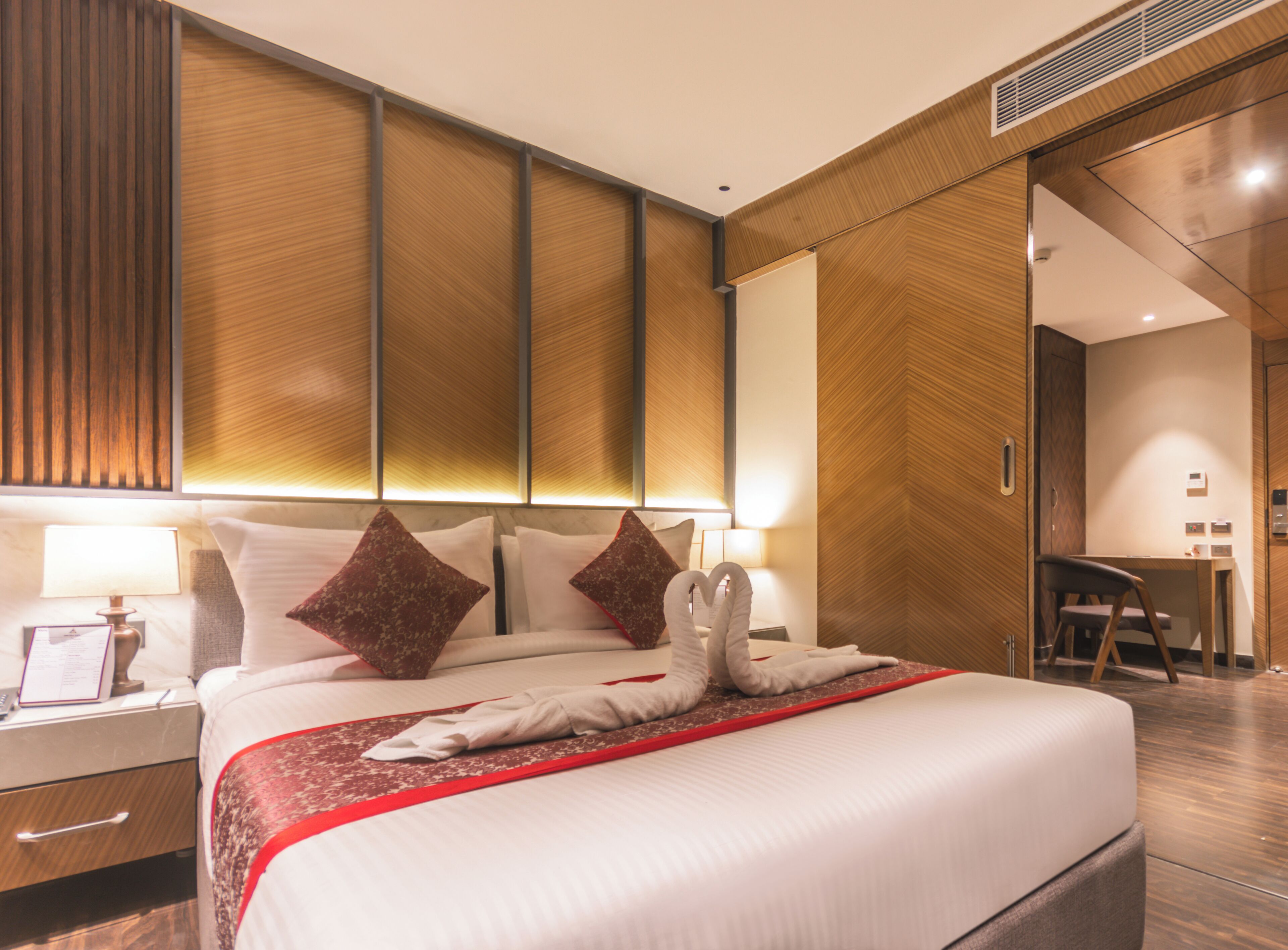 Una habitación de hotel con una cama bien hecha, un escritorio y una silla.
