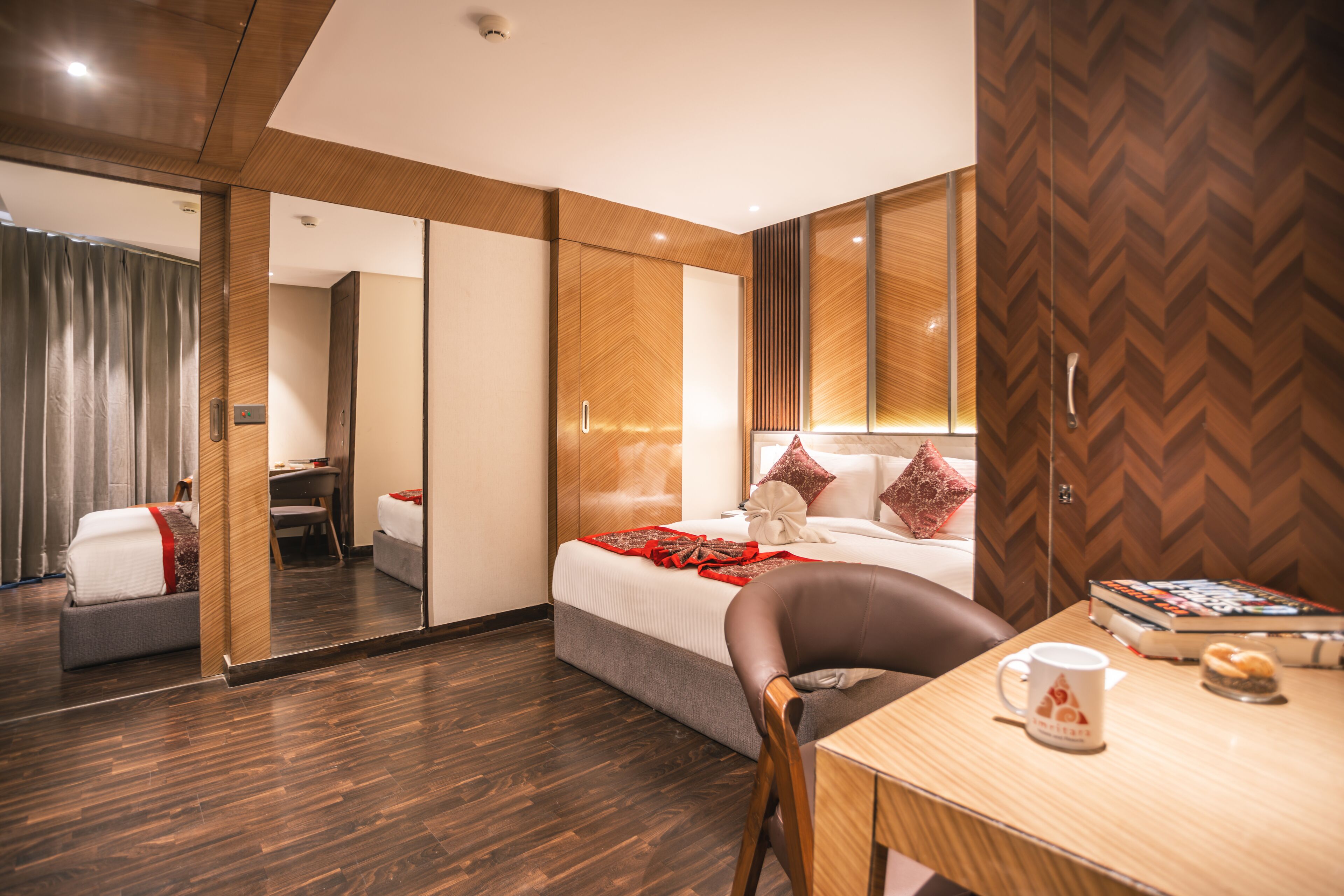 A modern hotel room with a bed, a desk, and a chair.
