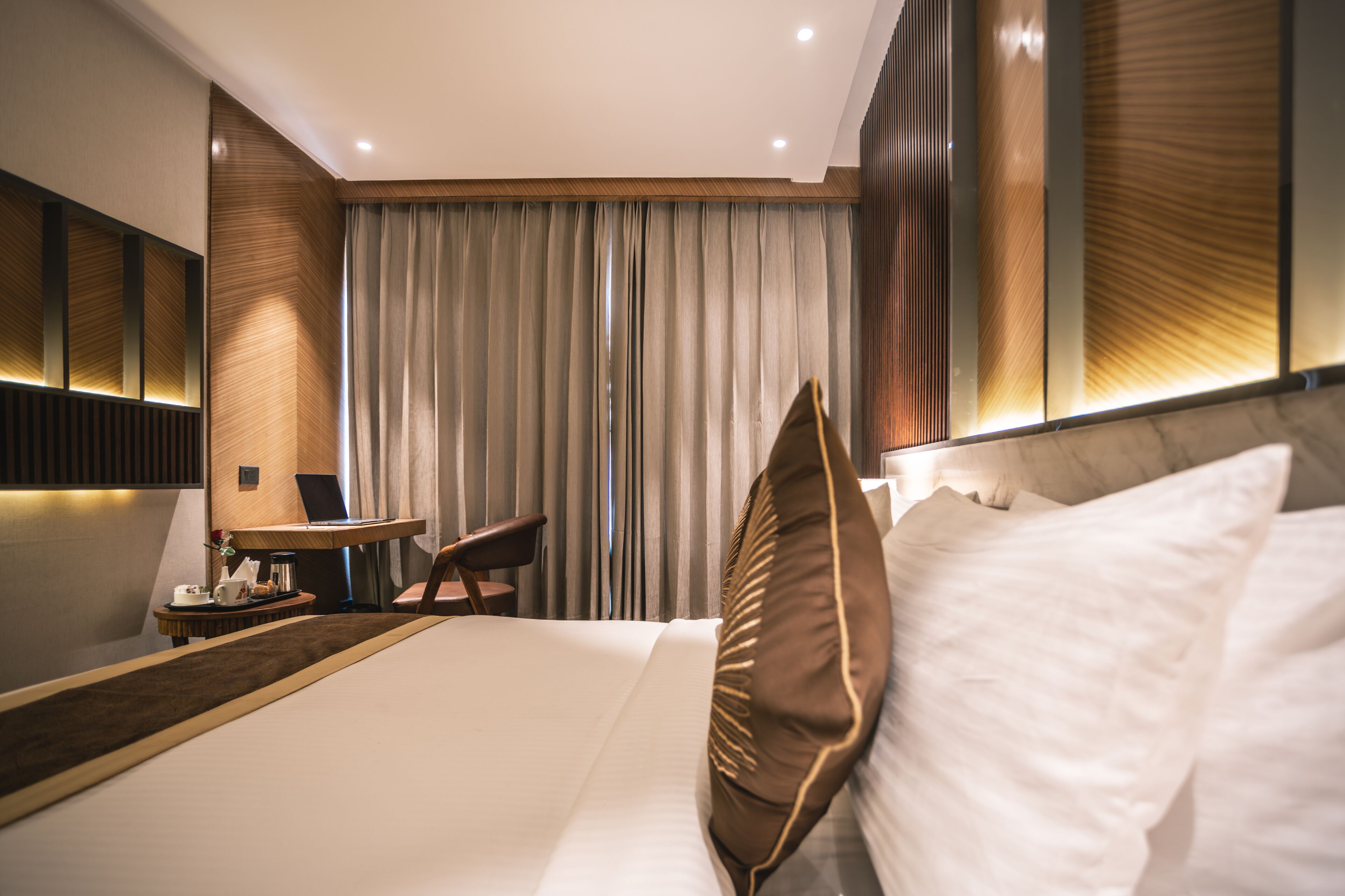 Ein modernes Hotelzimmer mit einem großen Bett, einem Schreibtisch und einem Stuhl.